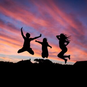 Silhouettes of teens jumping