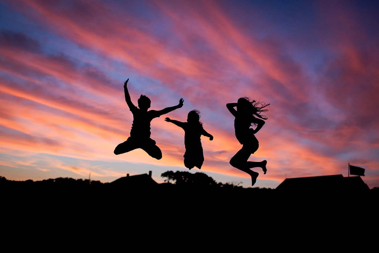 Silhouettes of teens jumping