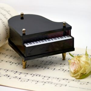 Image of piano sculpture and a rose on sheet music